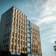 Fasade av bygget i solskinn, foto.