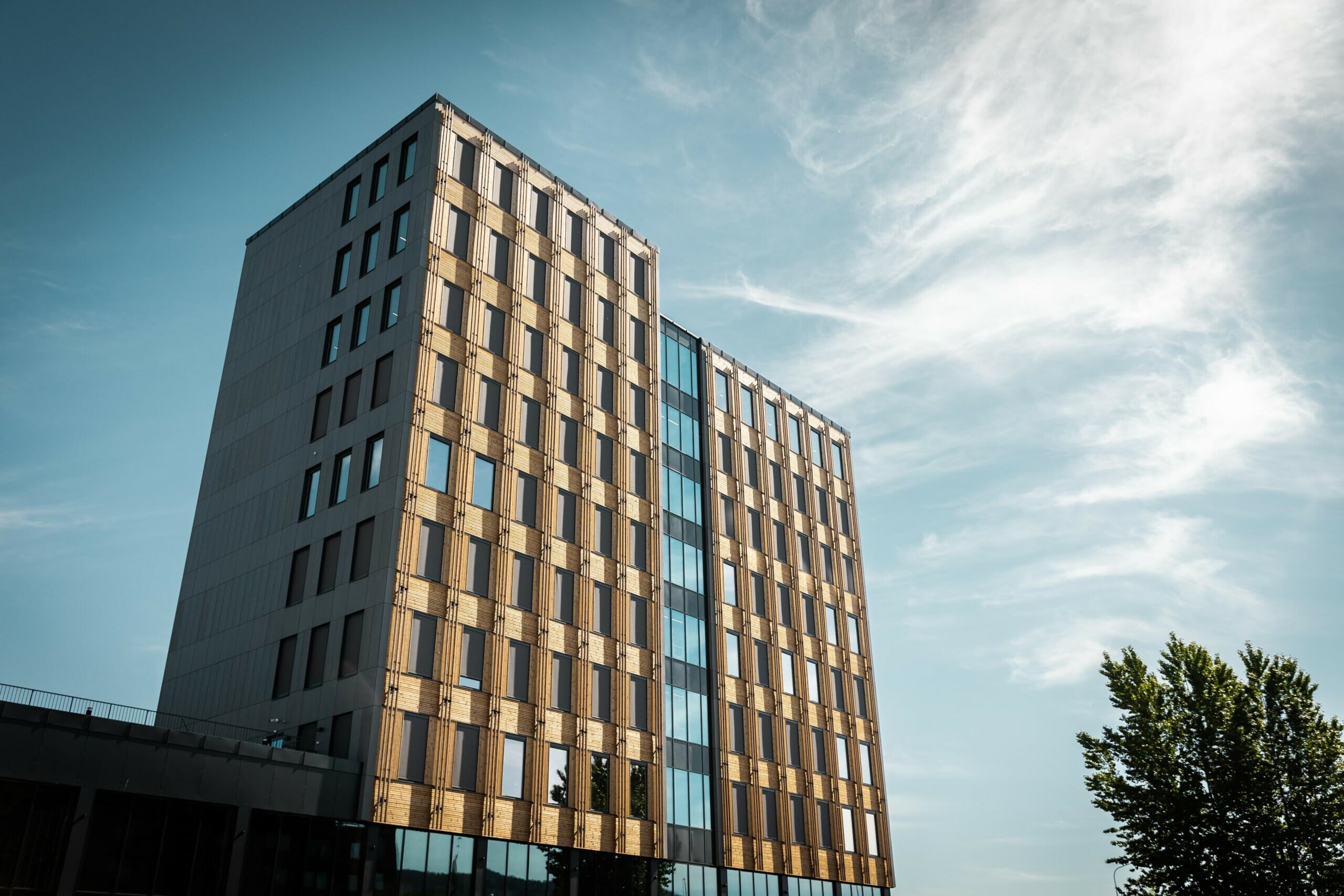 Fasade av bygget i solskinn, foto.