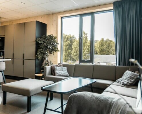 Splitkon_ModumAMB-16 Kantina med grå sofagruppe og svart kjøkken, foto.