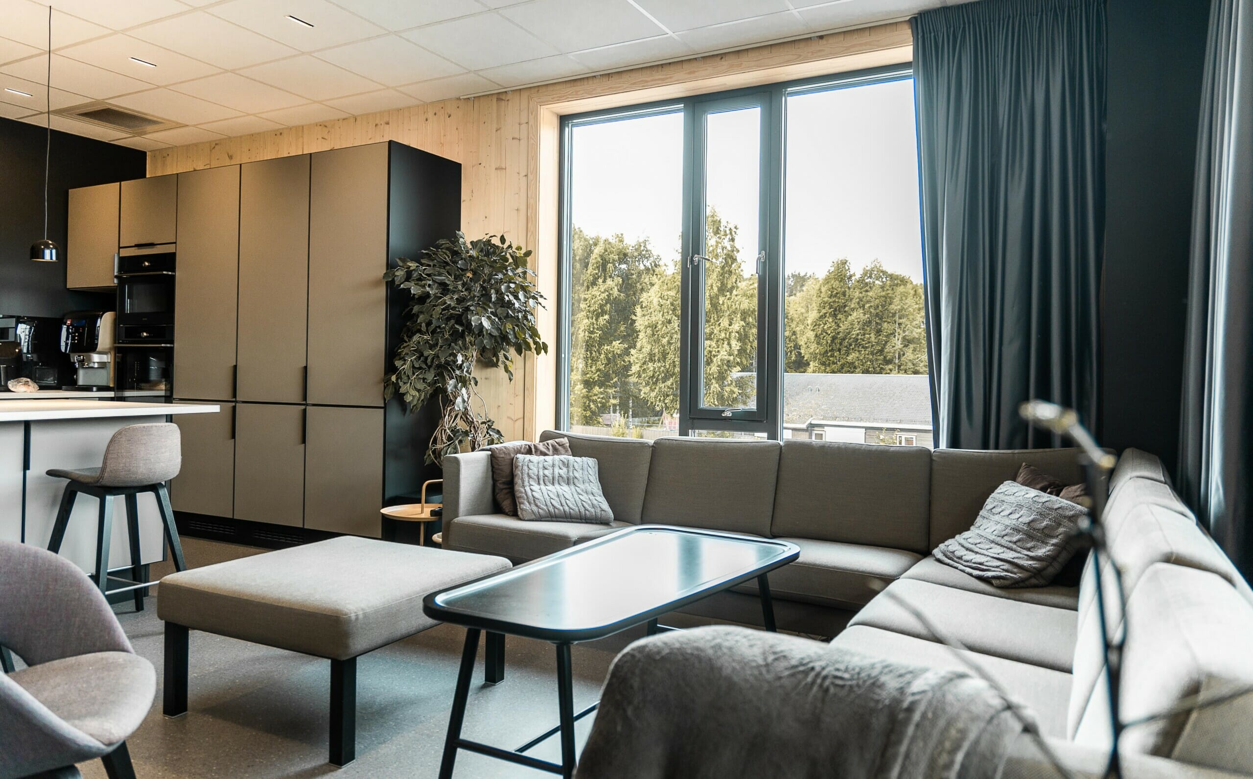 Splitkon_ModumAMB-16 Kantina med grå sofagruppe og svart kjøkken, foto.