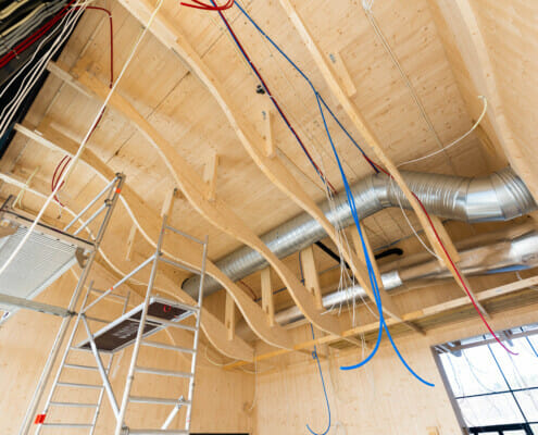 Splitkon_Modumambulansesentral (4 of 9) Taket under bygging med masse ledninger og rør hengende, foto.