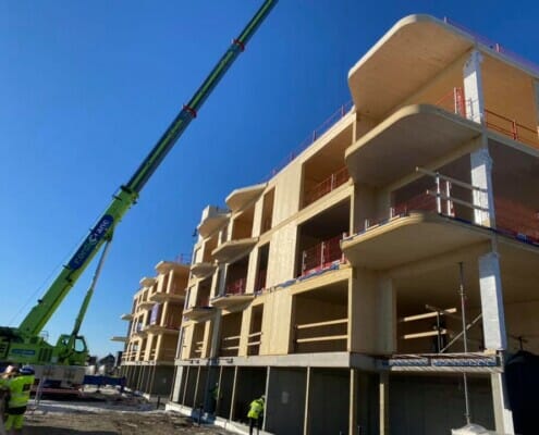 Kranbil utenfor fasaden under bygging, foto.