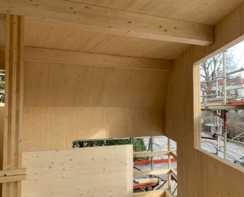 278045879_10160089337024085_7773823758515881704_n Underveis i byggingen med fokus inne og på vegger i massivtre, foto.