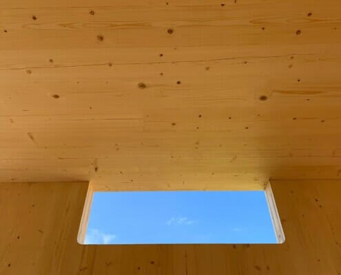 Åpning i treverket med utsikt til himmelen, foto.