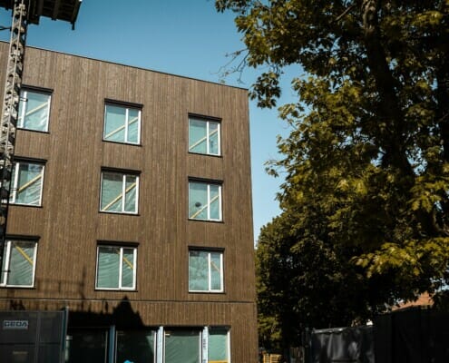 Splitkon_Tåsen-1 Utvendig fasade av bygningen mørkebrun front og sol som skinner, foto.